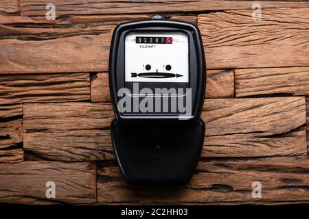 Close-up di un kilowatt contatore elettrico sulla scrivania in legno Foto Stock