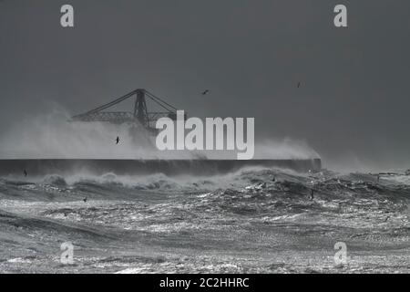 Parete nord del porto di Leixoes durante la tempesta pesante vedendo la sua vecchia e iconica gru enorme, costa nord portoghese. Foto Stock