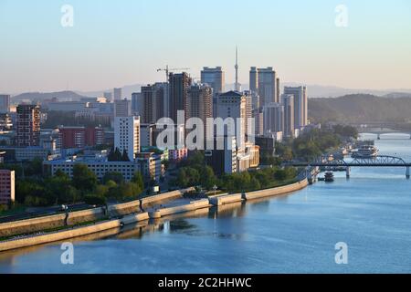 Alba a Pyongyang, Corea del Nord e Taedong fiume nella nebbia mattutina. Vista verso monte, moderno complesso residenziale e nuovo cantiere. Vi Foto Stock