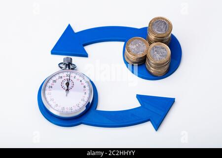 Monete impilate e cronometro in tempo di scambio per il concetto di denaro Foto Stock