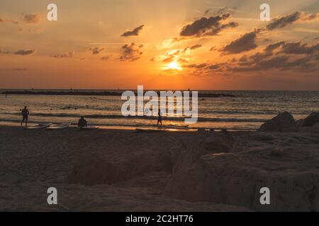 Sagome di persone sulla spiaggia di Tel Aviv nel tramonto panoramico Foto Stock