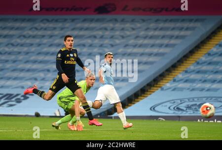 Sergio Aguero (centro) di Manchester City vede il suo colpo colpire il posto che conduce a Phil Foden (non illustrato) per segnare il terzo gol del suo lato della partita durante la partita della Premier League allo stadio Etihad, Manchester. Foto Stock