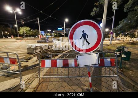 Cantiere stradale di notte con cartello di avvertimento e deviazione per pedoni Foto Stock