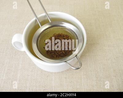 Tè dai semi di cumino e frutta di cumino nel filtro del tè Foto Stock