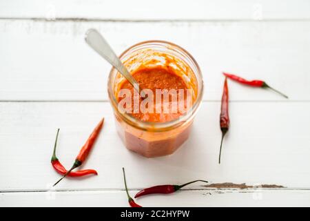 La salsa di Piri Piri è un tipo di salsa di peperoncino piccante usata come condimento o marinata tradizionalmente nella cucina portoghese. Visto qui in un vaso di vetro. Foto Stock