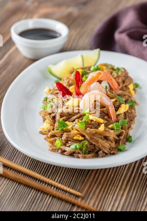 Piatto di Pad Thai - Thai fried rice noodles sullo sfondo di legno Foto Stock