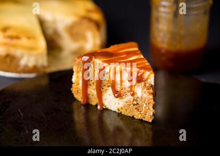 Fetta di torta di marmo che è un mix di torta di carote e cheesecake roteati insieme e conditi con salsa al caramello. Un delizioso dolce cremoso. Foto Stock