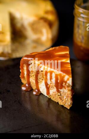 Fetta di torta di marmo che è un mix di torta di carote e cheesecake roteati insieme e conditi con salsa al caramello. Un delizioso dolce cremoso. Foto Stock