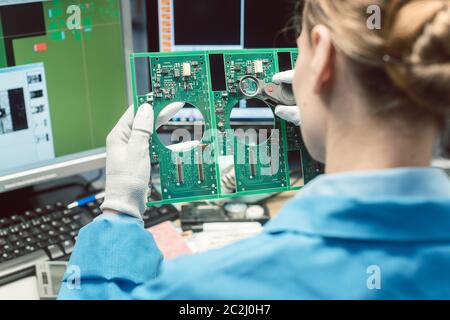 Controllo ottico della qualità e ispezione di montaggio di un prodotto elettronico in fabbrica Foto Stock