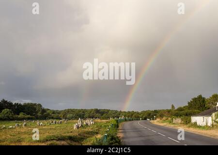 Rainbow su allineamenti di Menec - file di menhir - pietre permanente - il più grande sito megalitico nel mondo vicino a Carnac in Bretagna, Francia Foto Stock