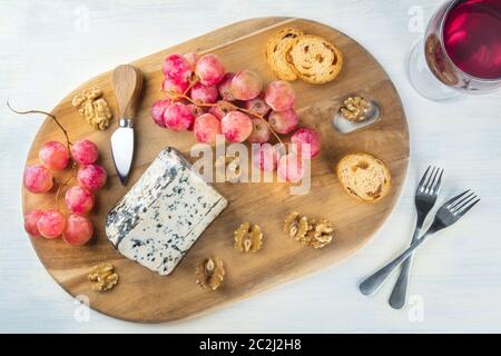 Il Gorgonzola, ripresa dall'alto con uve, dadi e un bicchiere di vino Foto Stock