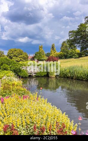 Vista in RHS Garden Wisley del torrente e stagni tra Oakwood e il prato alpino e Giardino di roccia, in estate Foto Stock