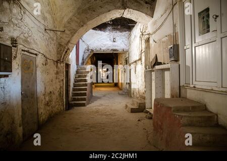 Vecchio tunnel abbandonato nella cantina sotterranea delle baraccopoli. Ingresso alle catacombe urbane. Sotto la città sorpasso cemento vecchio usura r Foto Stock