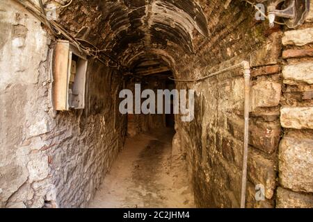 Vecchio tunnel abbandonato nella cantina sotterranea delle baraccopoli. Ingresso alle catacombe urbane. Sotto la città sorpasso cemento vecchio usura r Foto Stock