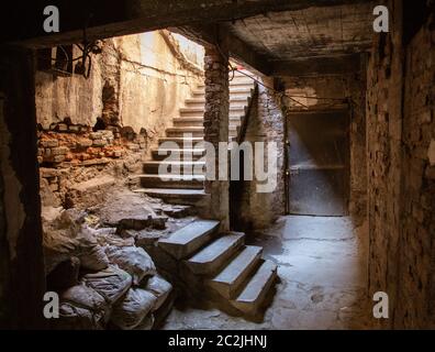 Vecchio tunnel abbandonato nella cantina sotterranea delle baraccopoli. Ingresso alle catacombe urbane. Sotto la città sorpasso cemento vecchio usura r Foto Stock