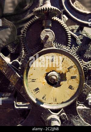 antico orologio in ferro arrugginito con viso stagionato e meccanismo complesso esposto con denti e ingranaggi Foto Stock