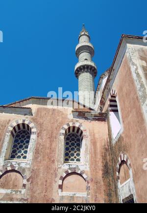 la moschea suleiman nella città vecchia di rodi con alto minareto contro un cielo blu illuminato dal sole Foto Stock