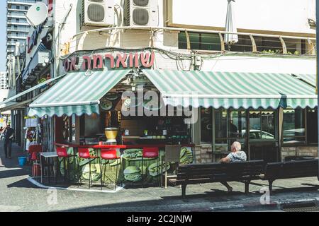 Tel Aviv/Israel-10/10/18: Un vecchio seduto fuori dalla stalla shawarma all'angolo di una strada a Tel Aviv. Piatto di cucina mediorientale, shawarma i Foto Stock