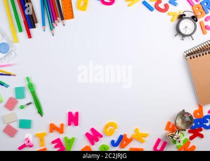 Set di scuola di diversi elementi colorati per l'apprendimento a scuola su uno sfondo bianco, metà spazio, vista dall'alto, il concetto di ritorno a scuola Foto Stock