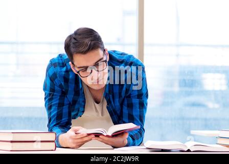 Studente nella libreria vuota con libro preparando per ex Foto Stock