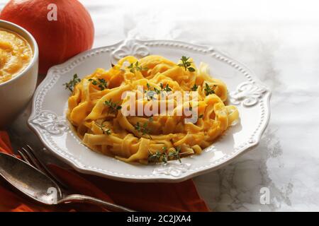 Tagliatelle pastawith Crema di zucca salsa sopra lo sfondo nero. Foto Stock