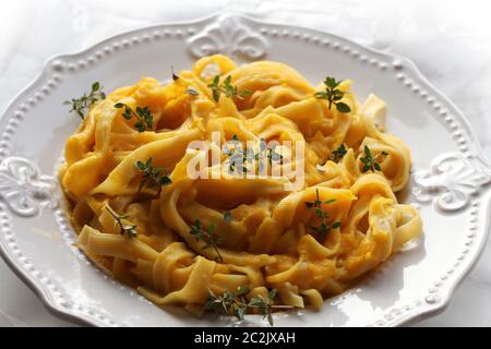 Tagliatelle pastawith Crema di zucca salsa sopra lo sfondo nero. Foto Stock