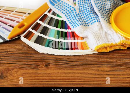 Vari strumenti di pittura, gli accessori e i campioni di colore per il restauro di casa su sfondo di legno . Foto Stock