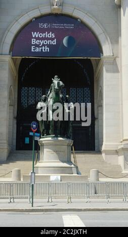 NEW YORK, NY: GIUGNO 17: Una statua del presidente degli Stati Uniti Theodore Roosevelt su un cavallo con una persona indigena che cammina accanto a lui sulla sua destra e una persona afroamericana che cammina accanto al suo lato sinistro è raffigurata all'ingresso del Museo di Storia Naturale. Per anni, questo simbolo della superiorità americana ha adornato il museo anche come le richieste per la sua rimozione sono state numerose. Una pattuglia della NYPD si trova di fronte alla statua per la protezione durante la rivolta americana il 17 giugno 2020 a New York City. Credit: Mpi43/MediaPunch Foto Stock