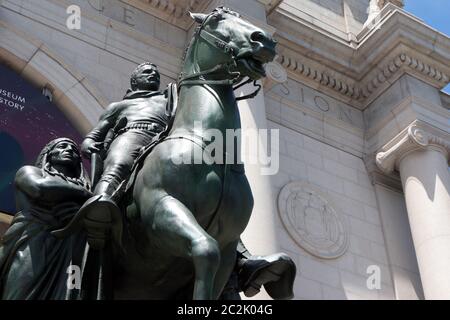 NEW YORK, NY: GIUGNO 17: Una statua del presidente degli Stati Uniti Theodore Roosevelt su un cavallo con una persona indigena che cammina accanto a lui sulla sua destra e una persona afroamericana che cammina accanto al suo lato sinistro è raffigurata all'ingresso del Museo di Storia Naturale. Per anni, questo simbolo della superiorità americana ha adornato il museo anche come le richieste per la sua rimozione sono state numerose. Una pattuglia della NYPD si trova di fronte alla statua per la protezione durante la rivolta americana il 17 giugno 2020 a New York City. Credit: Mpi43/MediaPunch Foto Stock