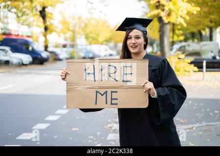 Studente laureato in piedi con noleggio di Me sulla targhetta Street Foto Stock