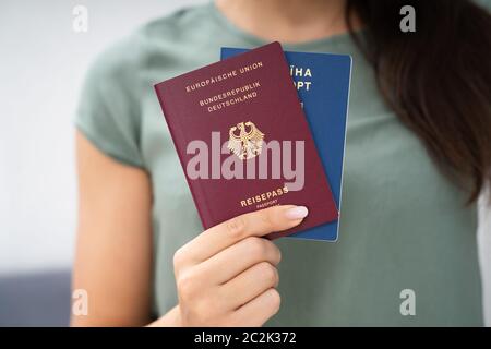 Donna che mantiene due passaporti. In Ucraina e in tedesco Foto Stock