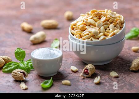 Arachidi salate fritte in un recipiente bianco. Foto Stock