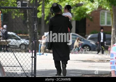 New York City, Stati Uniti. 17 Giugno 2020. Un padre è visto trasportare il suo bambino nel parco giochi di Middleton nella sezione di Williamsburg del distretto di Brooklyn di New York City, NY, 17 giugno 2020. Citando che i parchi giochi fanno parte dei parchi cittadini che sono essi stessi aperti, gli attivisti della comunità hanno usato tagliabulloni per sbloccare i cancelli, nonostante gli ordini che i parchi giochi rimangono chiusi per contenere la diffusione di COVID-19.(Anthony Behar/Sipa USA) Credit: Sipa USA/Alamy Live News Foto Stock