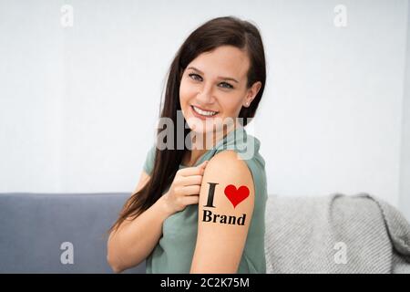 La donna che mostra il suo Io amo la marca Tattoo Foto Stock