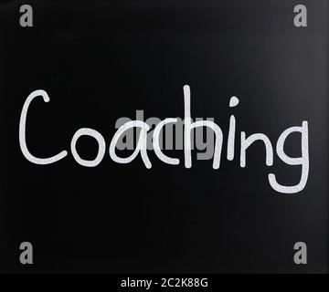 Manoscritte di coaching con il bianco gesso su una lavagna Foto Stock