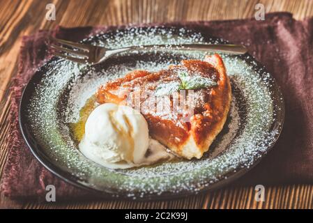 Porzione di Tarte Tatin decorate con menta fresca e servita con sfera di gelato Foto Stock
