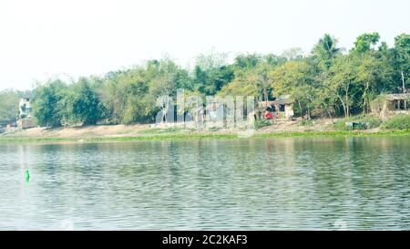 Gange fiume shore (nome locale Damodar ) nel tempo al tramonto con lussureggiante tropicale delle pianure di Gangetic nella Purbasthali, West Bengal, India. Un India rurale landsc Foto Stock