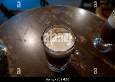 Pinta di birra scura su un vecchio tavolo di legno e pub irlandese Foto Stock