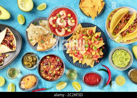 Cibo messicano, molti piatti della cucina del Messico, piatto a stendere sopra un'immagine su di un vibrante sfondo blu. Nachos, tequila, g Foto Stock