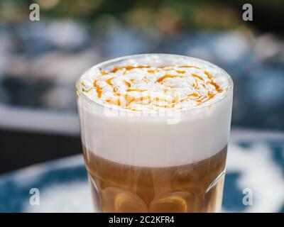 Caffè latte macchiato caldo con caramello all'aperto Foto Stock
