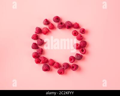 Layout creativo con bacche fresche mature. Raspberry su sfondo rosa con cerchio vuoto rotondo al centro per lo spazio di copia. Può essere utilizzato per il tuo progetto. V. Superiore Foto Stock