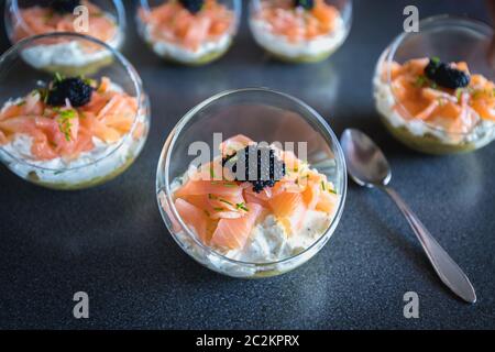 Salmone verrine ciclottero uovo formaggio fresco e letto di avocado in cucina Foto Stock