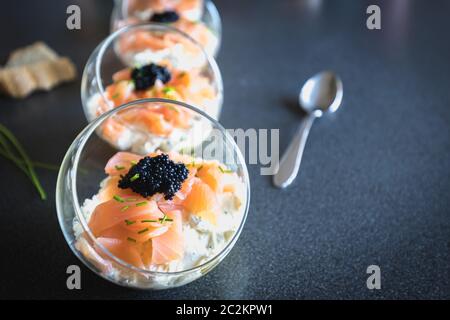 Salmone verrine ciclottero uovo formaggio fresco e letto di avocado in cucina Foto Stock