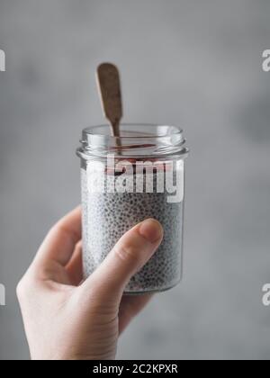 Chia pudding in mano di donna Foto Stock