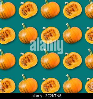 Disposizione geometrica delle zucche arancioni mature su sfondo verde scuro, tessitura vegetale colorata, modello alimentare vegano, sfondo autunno Haloween Foto Stock