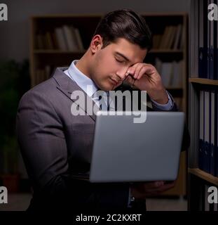 Imprenditore quasi addormentarsi a lavorare fino a tardi in ufficio Foto Stock