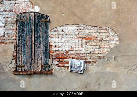 Edificio abbandonato con vecchio asciugamano in linea contro vecchi muri di mattoni danneggiati, Lombardia, Italia Foto Stock