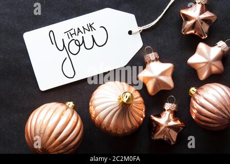 Una etichetta con la calligrafia inglese Grazie. Golden palla di Natale ornamento su sfondo nero. Foto Stock