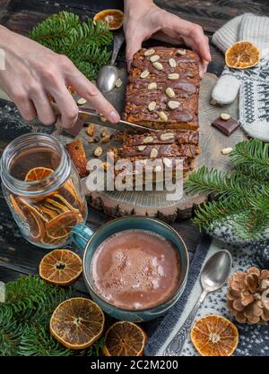 Mani femminili affettando la torta a fette. Foto Stock