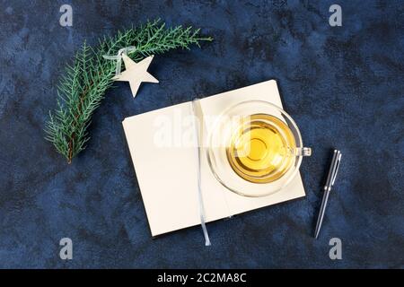 Risoluzioni di nuovo anno, scatto a sovrapposizione piatto con spazio di copia, su uno sfondo blu scuro con una decorazione di Natale e una tazza di Foto Stock